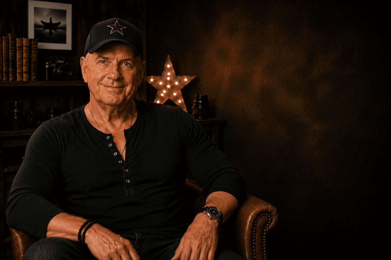 Tim Bennett seated in a warmly lit studio portrait